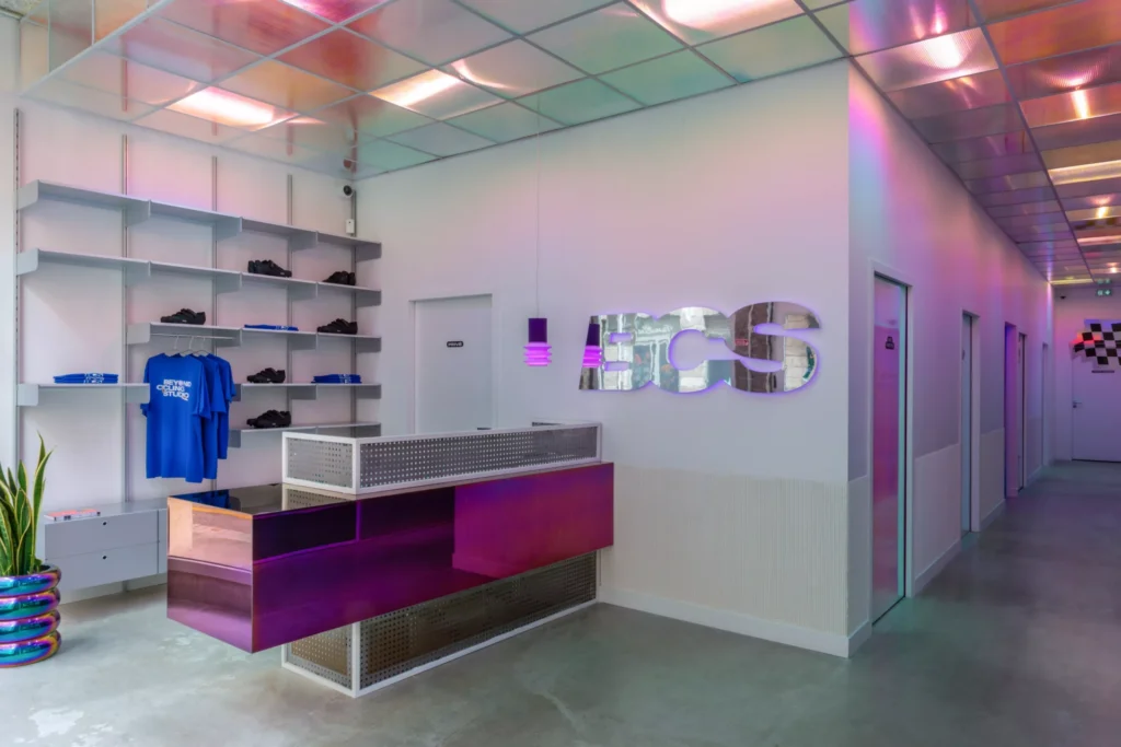 Espace réception design avec lettrage mural "BCS", ambiance lumineuse irisée réalisée par l’entreprise d’électricité Sauralec.